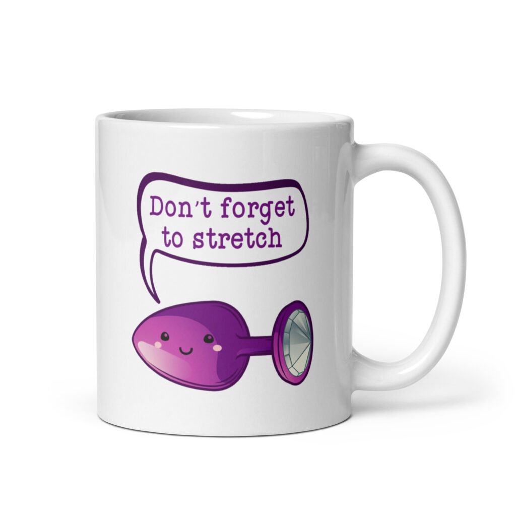 White ceramic coffee mug that has image of a purple anal plug with a smile face. There is a speech bubble above with the words 'Don't forget to stretch'. The graphics are printed on both sides of the mug.