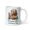 White ceramic coffee mug with an image of grey haired older woman enjoying a bite of a piece of cake with the words 'I hope your cake is as moist as I am' printed on both sides.