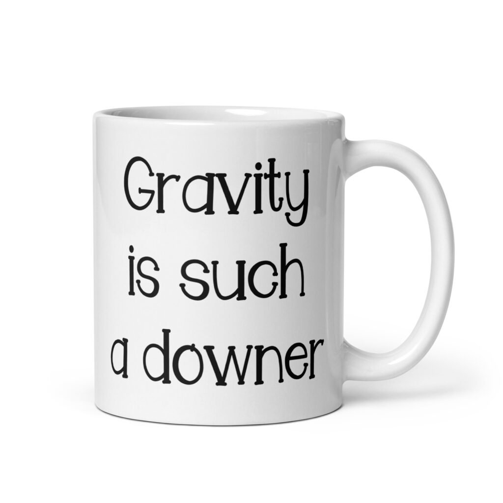 White ceramic coffee mug with the text 'Gravity is such a downer' printed on both sides.