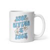 White ceramic coffee mug with a retro daisy and star design and the text 'Stop giving a fuck' printed on both sides.