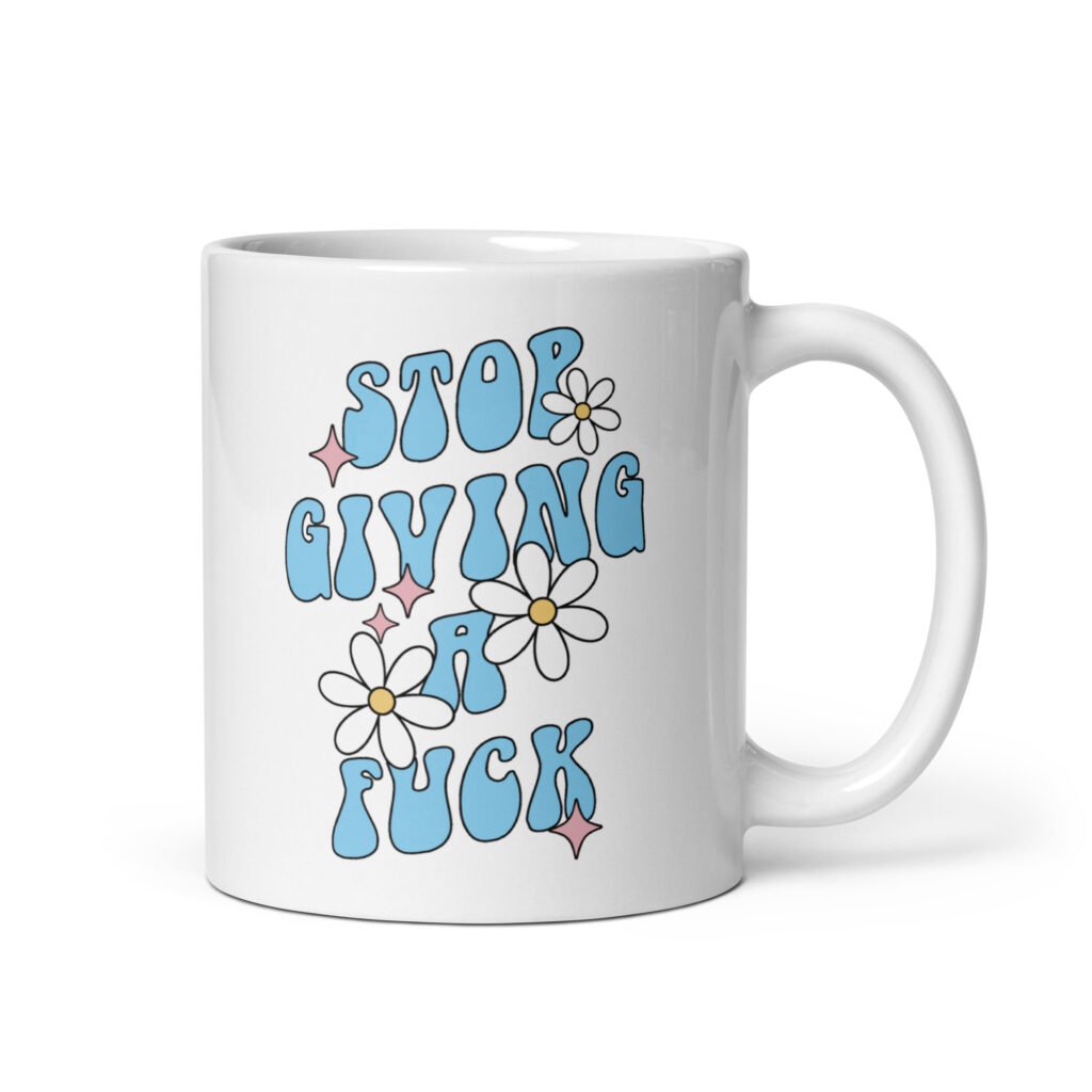 White ceramic coffee mug with a retro daisy and star design and the text 'Stop giving a fuck' printed on both sides.