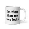 White ceramic coffee mug with the text 'I'm nicer than my face looks' printed on both sides.