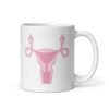 White ceramic coffee mug with with image of a pink uterus flipping middle finger graphic printed on both sides.