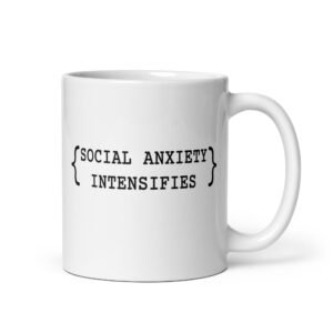 White ceramic coffee mug with the text 'Social anxiety intensifies' printed on both sides.