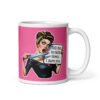 White ceramic coffee mug with pink color wrapped around. The mug has a graphic of an angry looking retro woman holding a knife and a sign. The sign says 'Tell me to calm down. I dare you.' The graphic is printed on both sides of the mug.
