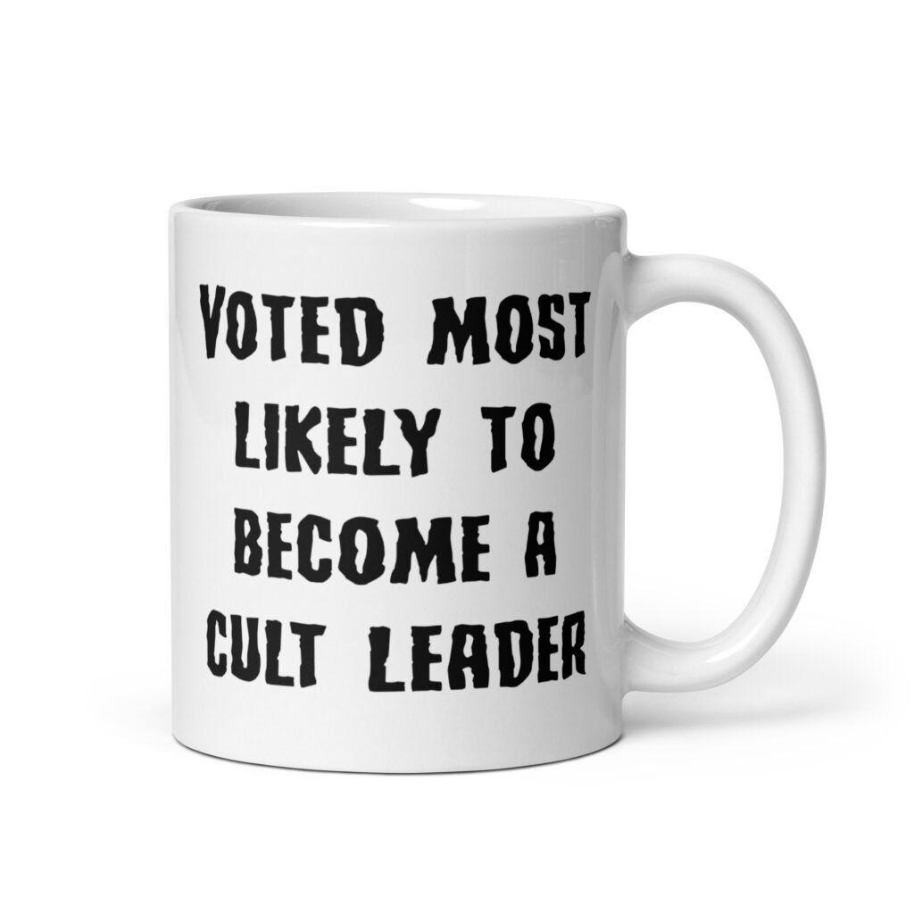 White ceramic coffee mug with the text 'Voted most likely to become a cult leader' printed on both sides.