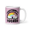 Pink and white ceramic coffee mug with a graphic of a kawaii style unicorn and a pastel rainbow with the text 'Everything is fucked' printed on both sides. The background is pink.