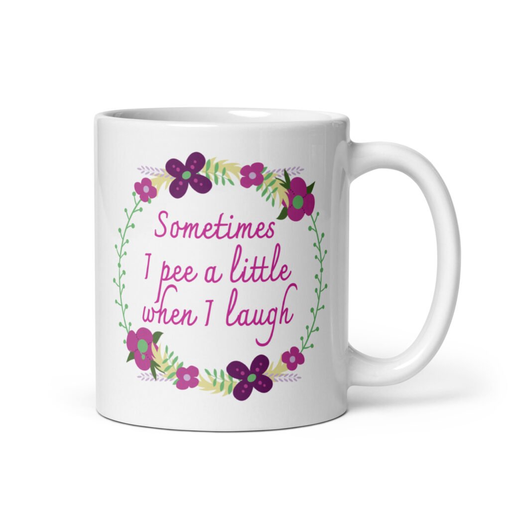White ceramic coffee mug that has a colorful minimalistic style line drawing floral wreath with the text 'Sometimes I pee a little when I laugh' printed in the center of the wreath. The graphics are printed on both sides of the mug.