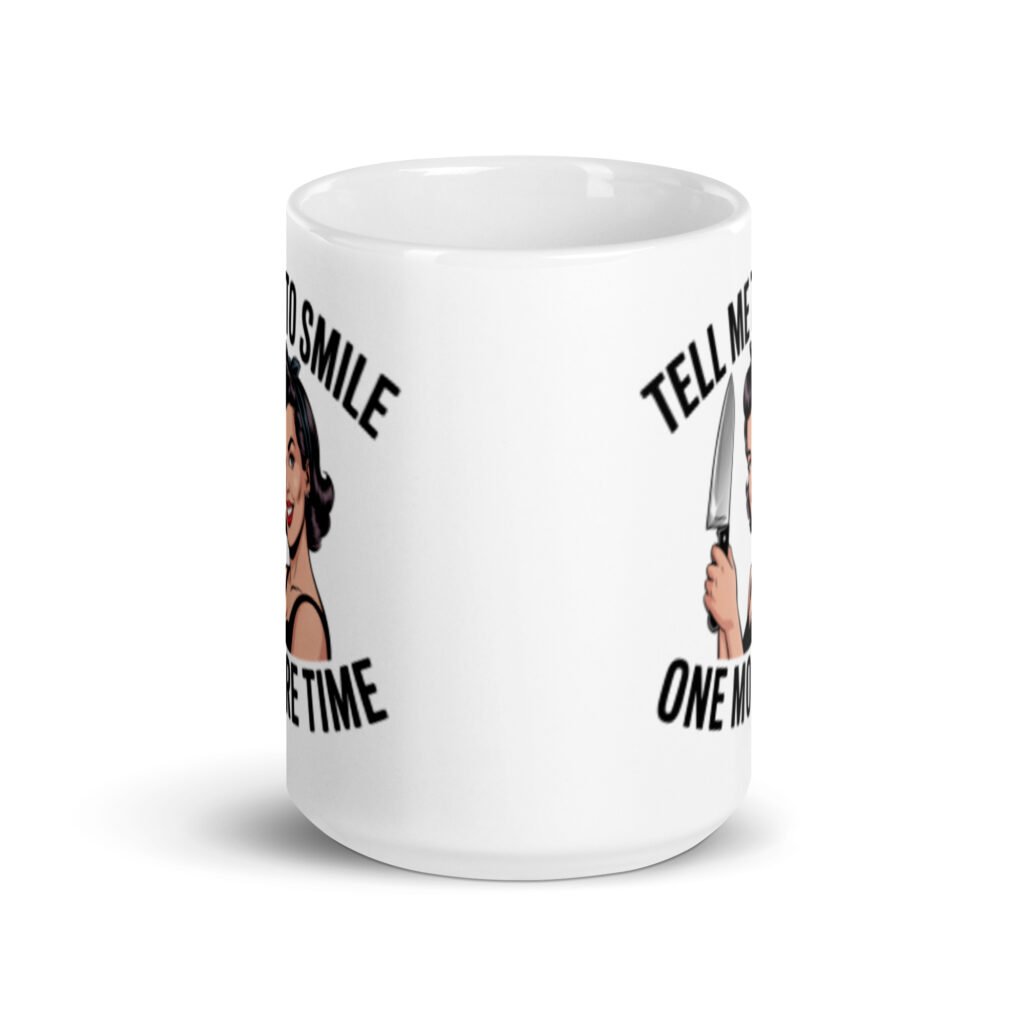 White ceramic mug with graphic of a woman holding a knife and the phrase 'Tell me to smile one more time' printed on both sides.