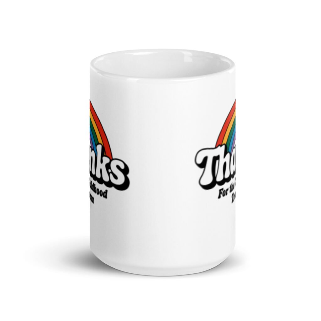 White ceramic mug with an image of a rainbow and the words 'Thanks for the childhood trauma' printed on both sides. The word Thanks is large and the rest of the words are smaller under.