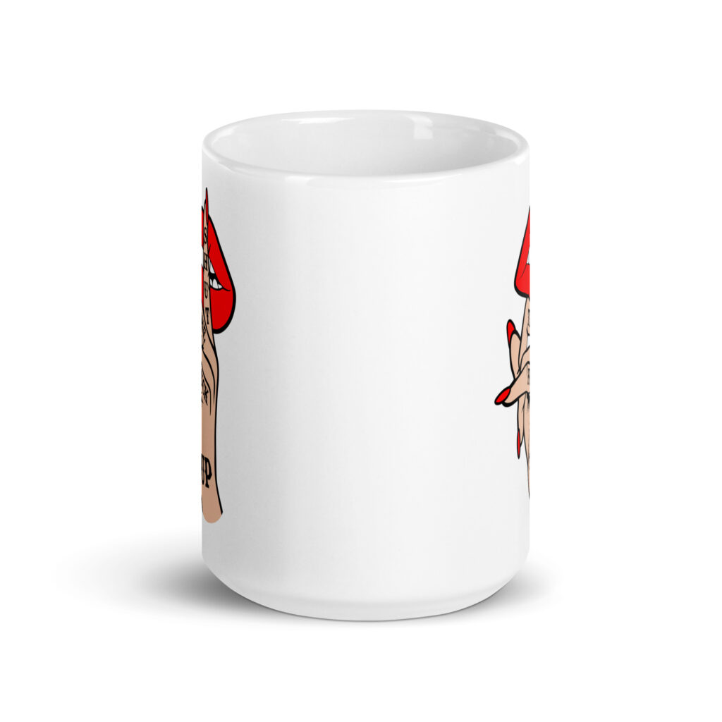 White ceramic mug with an image of a hand over lips making the shh gesture. The words 'Shut the fuck up' are printed on the hand. The graphics are printed on both sides of the mug.