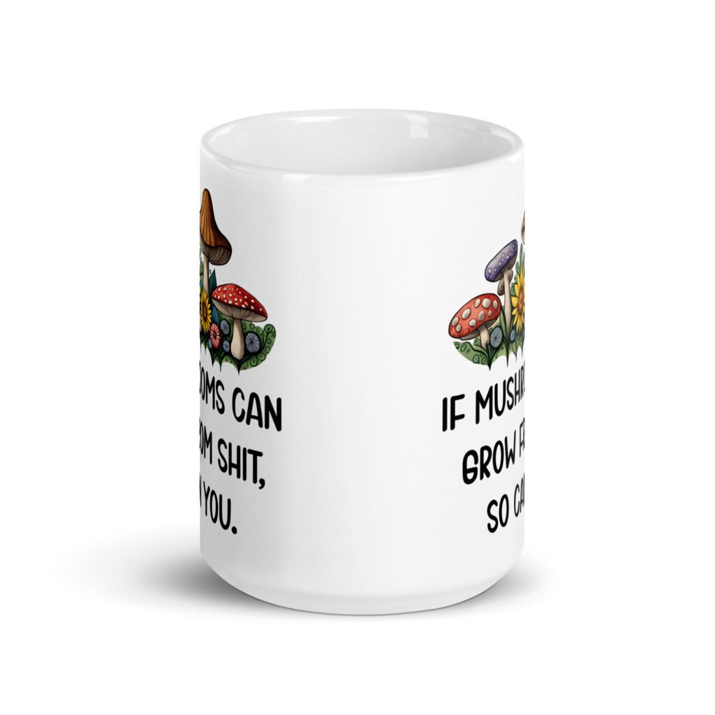 White ceramic coffee mug with images of mushrooms and the text 'If mushrooms can grow from shit so can you' printed on both sides.