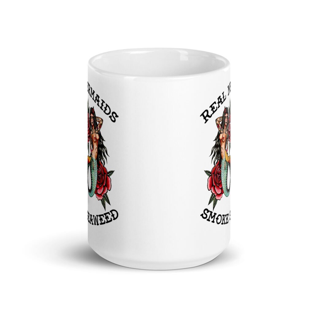 White ceramic mug with image of 2 mermaids and the text 'Real mermaids smoke seaweed' printed on both sides.