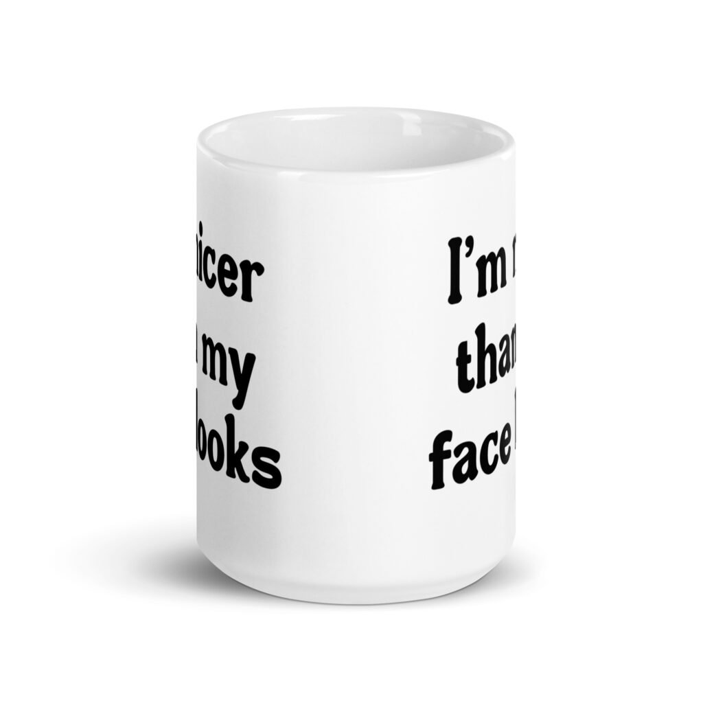 White ceramic coffee mug with the text 'I'm nicer than my face looks' printed on both sides.