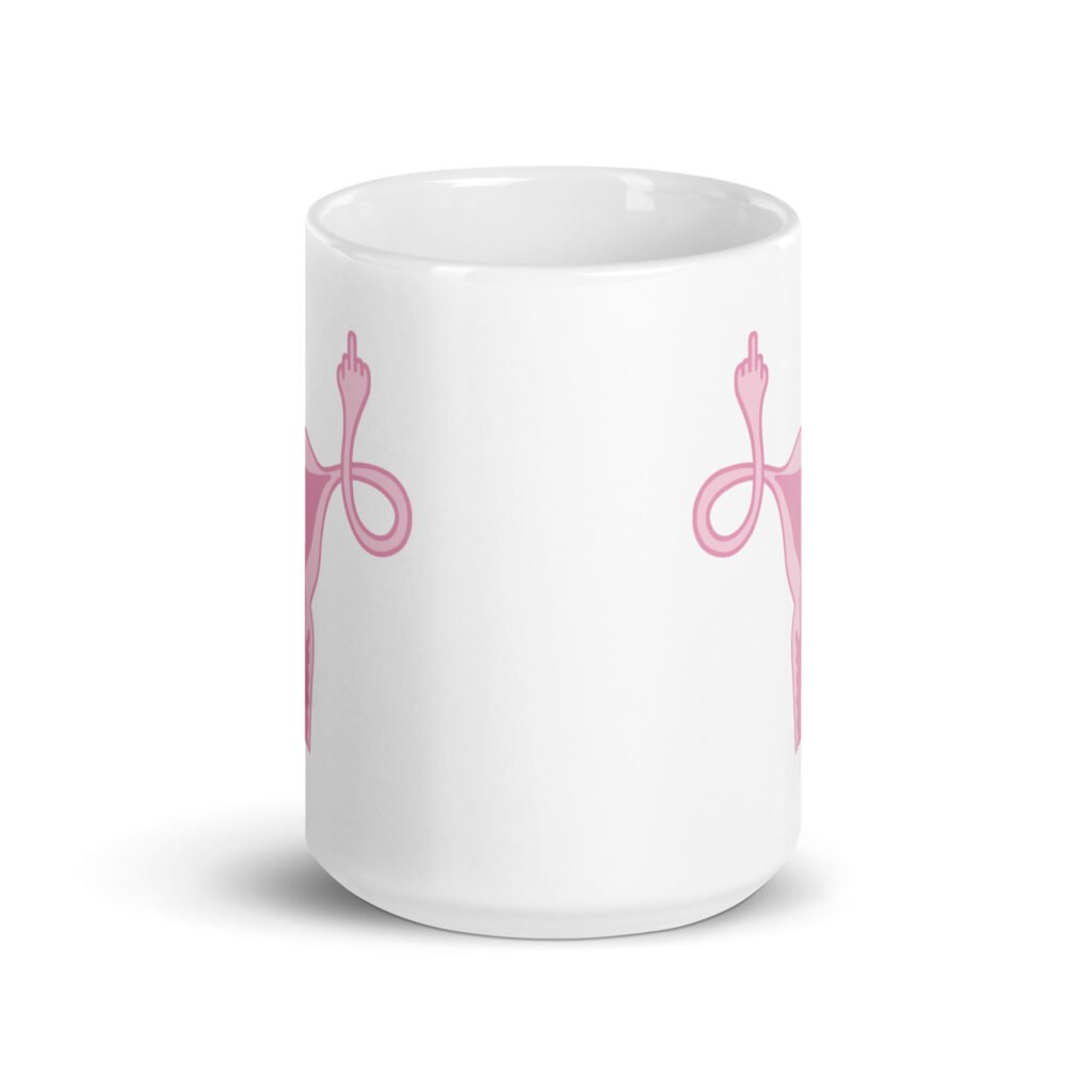 White ceramic coffee mug with with image of a pink uterus flipping middle finger graphic printed on both sides.