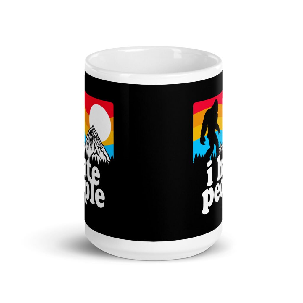 White coffee mug with graphic of Bigfoot walking into the sunset with the text 'I hate people' printed on both sides.