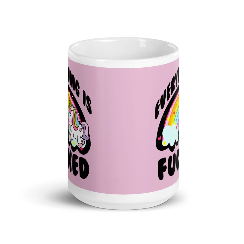 Pink and white ceramic coffee mug with a graphic of a kawaii style unicorn and a pastel rainbow with the text 'Everything is fucked' printed on both sides. The background is pink.