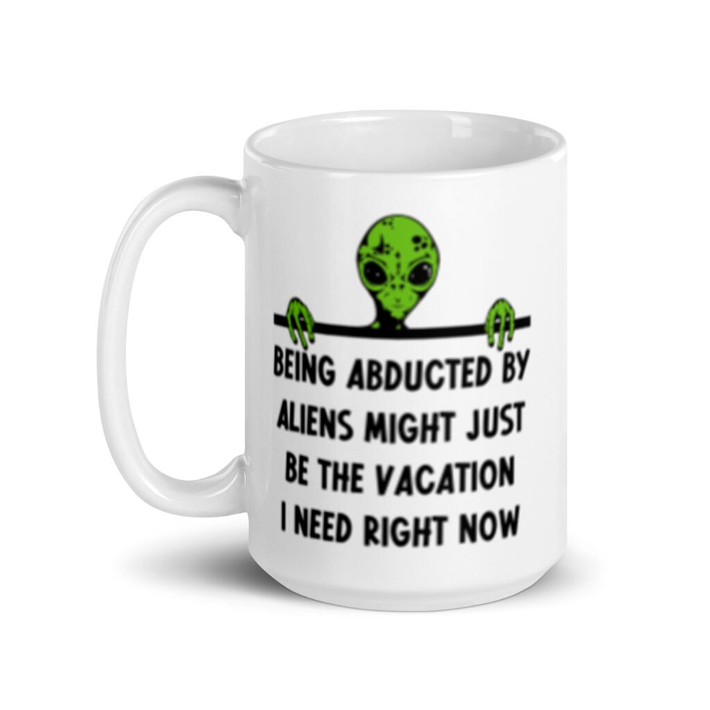 White ceramic mug with image of an alien and the words 'Being abducted by aliens might just be the vacation I need right now' printed on both sides.