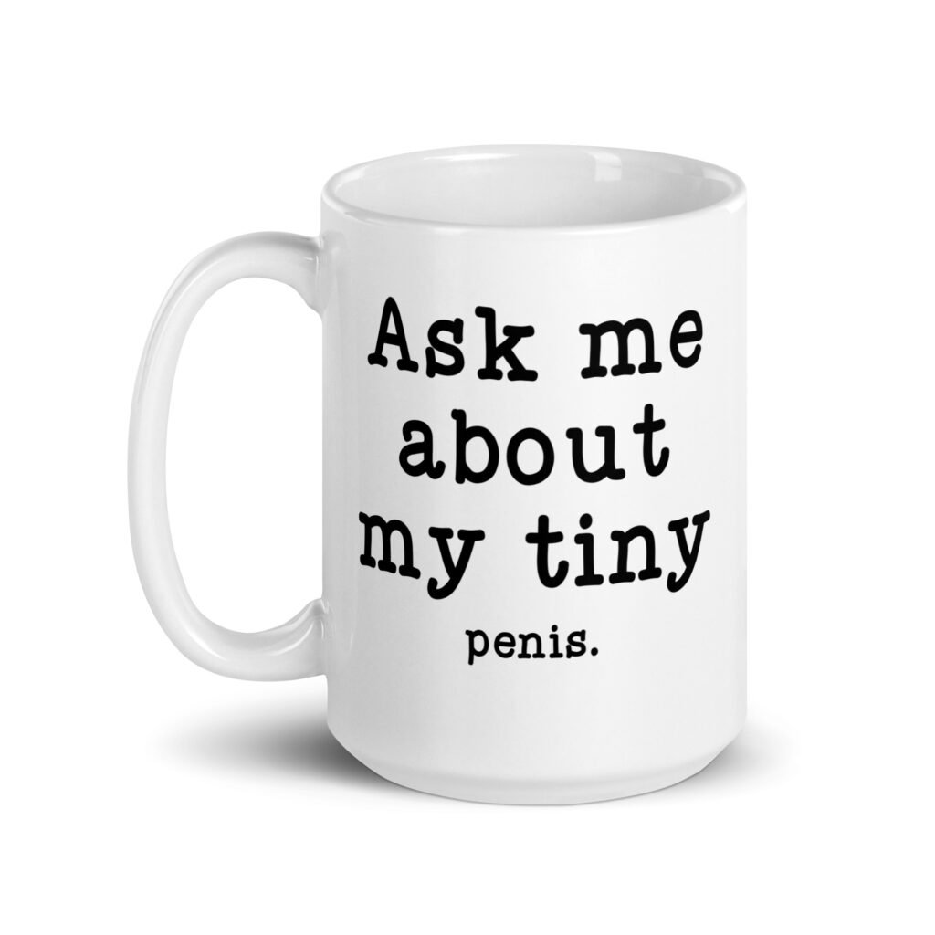 White ceramic mug with the text 'Ask me about my tiny penis' printed on both sides. The word tiny is much smaller than the rest of the text.