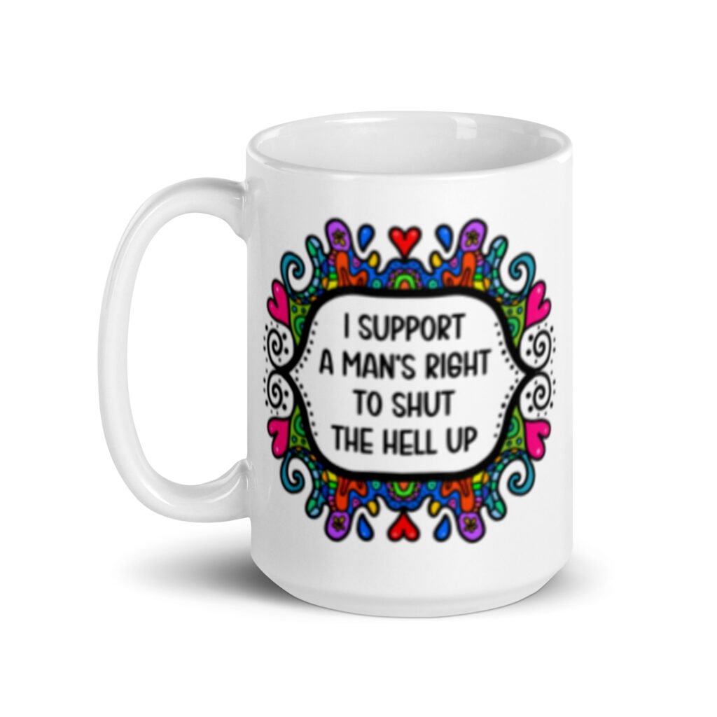 White ceramic mug with a colorful doodle graphic and the words 'I support a man's right to shut the hell up.' The design is printed on both sides of the mug.