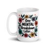 White ceramic mug with a multi color floral wreath design printed on both sides. The words 'One mental breakdown later...' are printed in the center of the wreath.