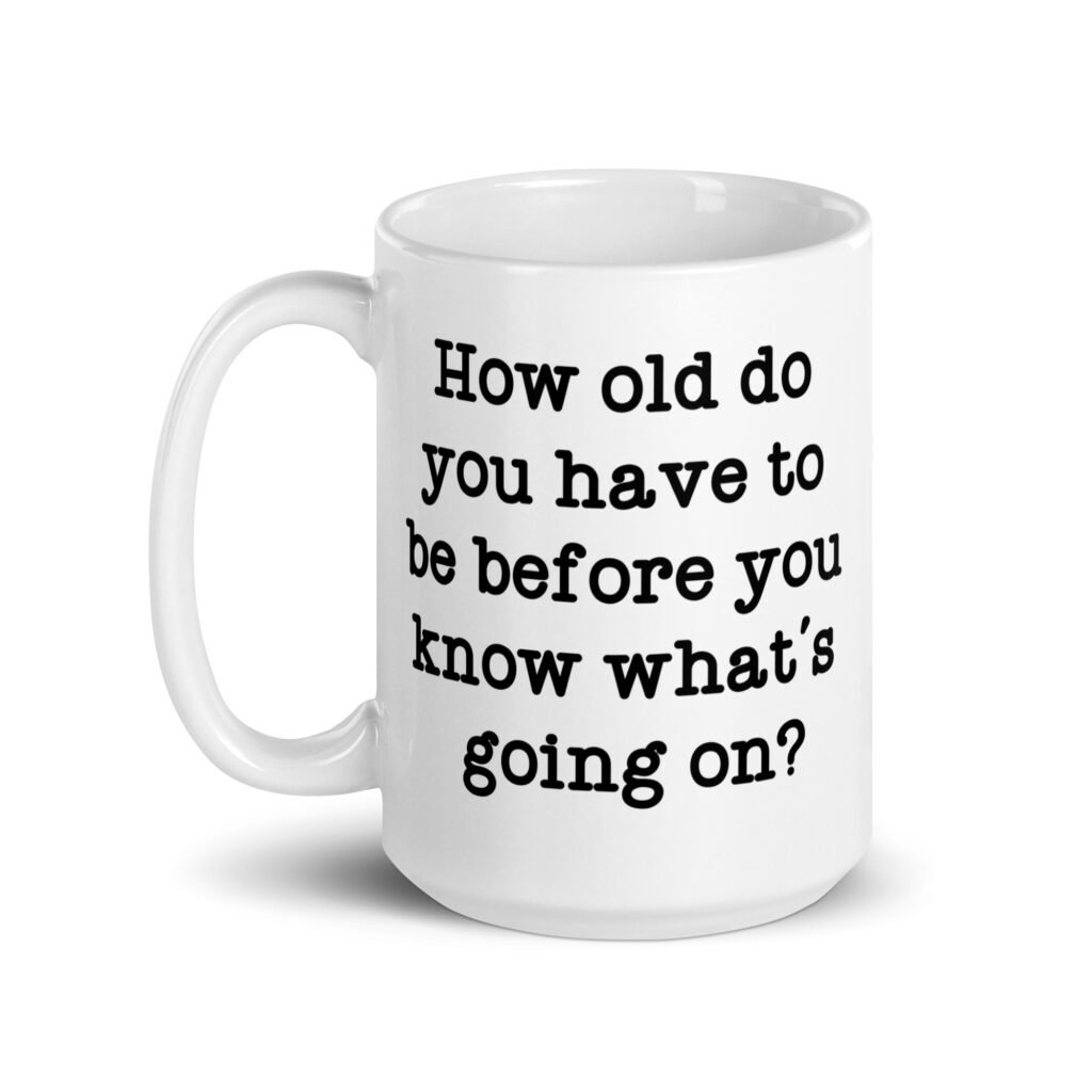 White ceramic mug with the text 'How old do you have to be before you know what's going on?' printed on both sides.