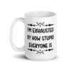 White ceramic coffee mug with the text 'I'm exhausted by how stupid everyone is' printed on both sides of the mug.