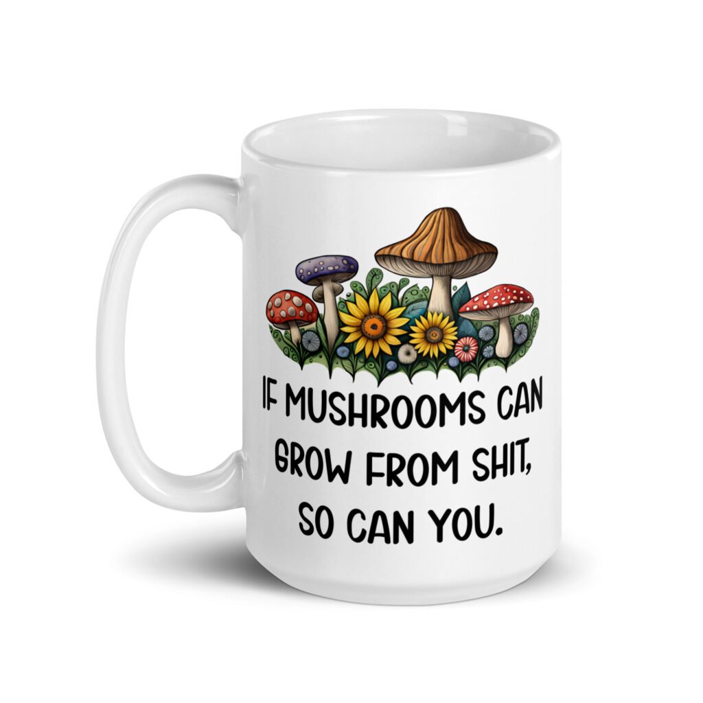 White ceramic coffee mug with images of mushrooms and the text 'If mushrooms can grow from shit so can you' printed on both sides.