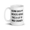 White ceramic mug with the phrase 'Holding back my sarcastic replies takes a lot of inner strength' printed on both sides of the mug.