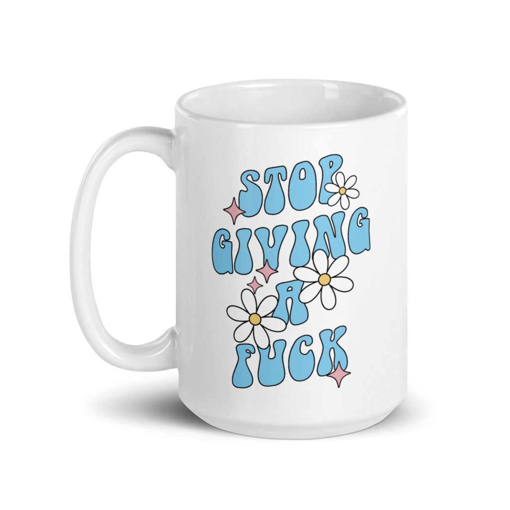 White ceramic coffee mug with a retro daisy and star design and the text 'Stop giving a fuck' printed on both sides.