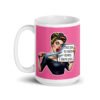 White ceramic coffee mug with pink color wrapped around. The mug has a graphic of an angry looking retro woman holding a knife and a sign. The sign says 'Tell me to calm down. I dare you.' The graphic is printed on both sides of the mug.