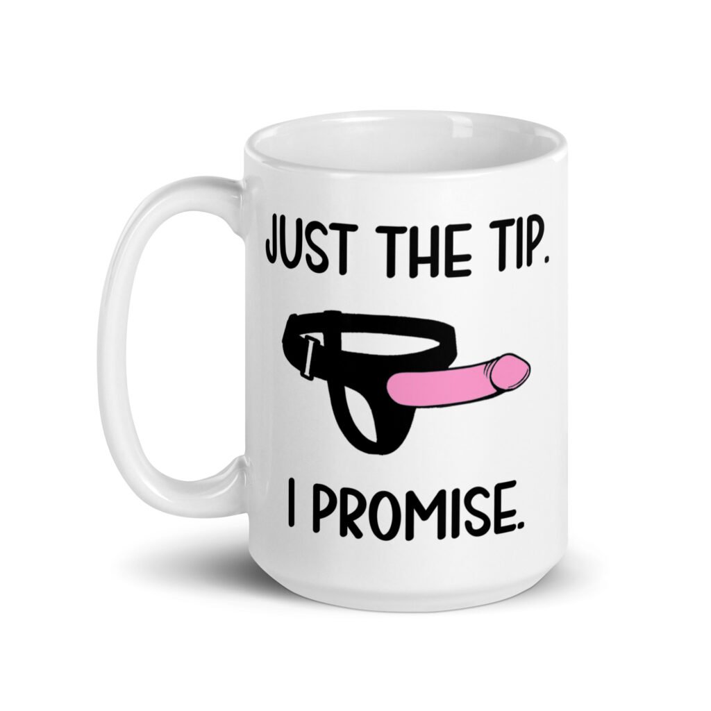 White ceramic coffee mug that has an image of a strap-on dildo and the words 'Just the tip. I promise.' printed on both sides.