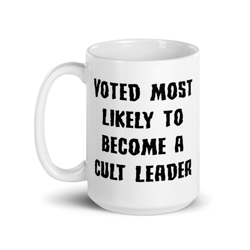 White ceramic coffee mug with the text 'Voted most likely to become a cult leader' printed on both sides.