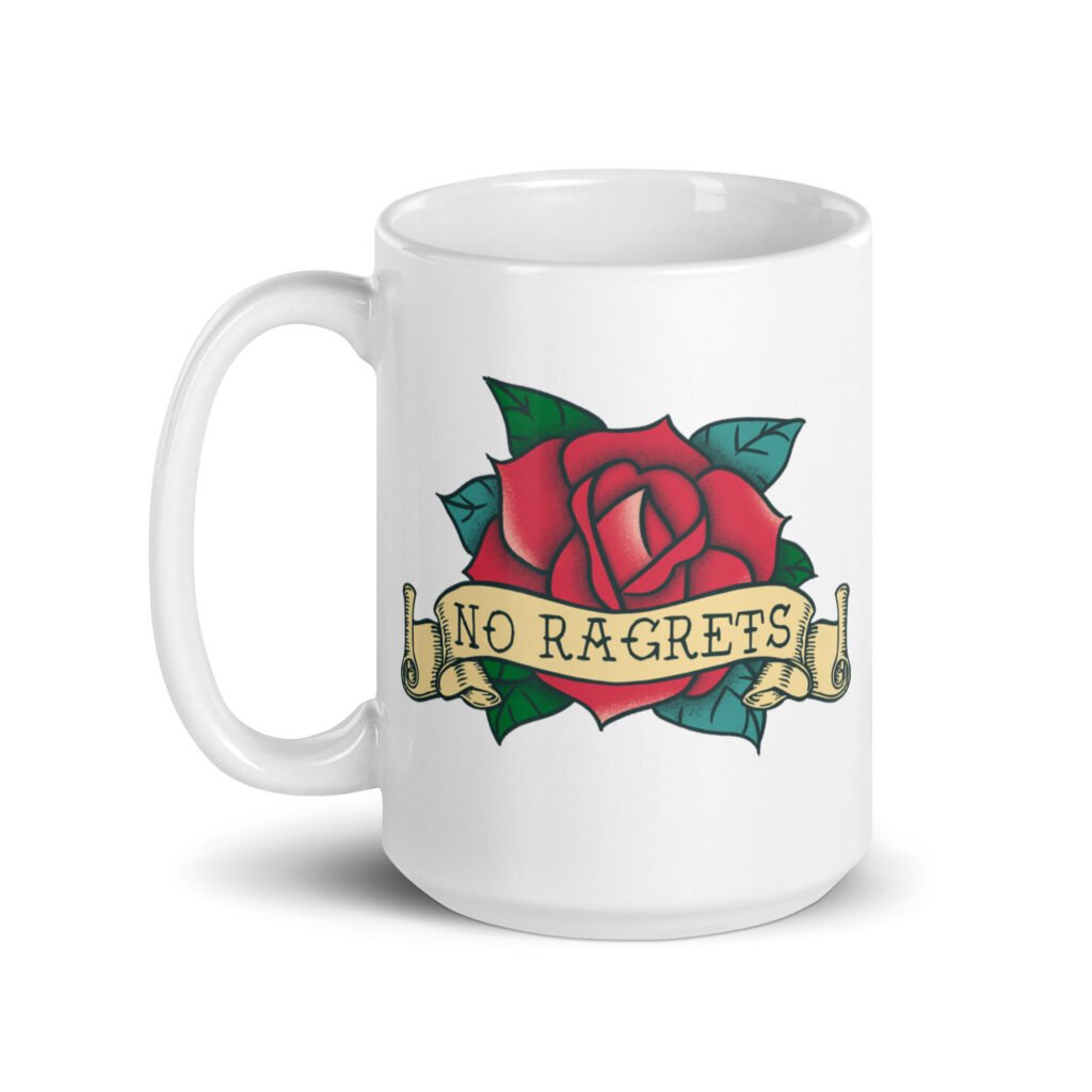 White ceramic coffee mug with funny image of an old school rose flash tattoo with the words 'No ragrets' intentionally misspelled. The graphics are printed on both sides of the mug.
