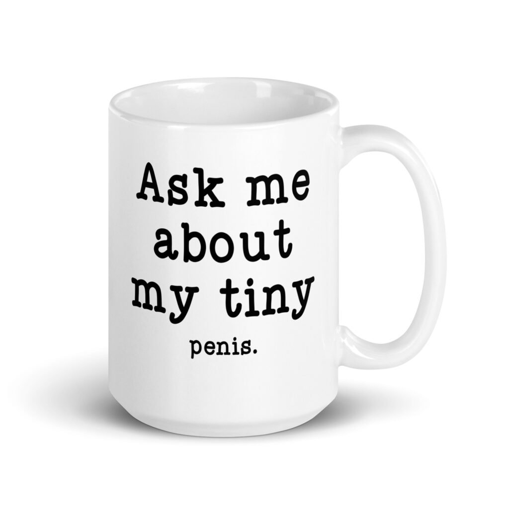 White ceramic mug with the text 'Ask me about my tiny penis' printed on both sides. The word tiny is much smaller than the rest of the text.