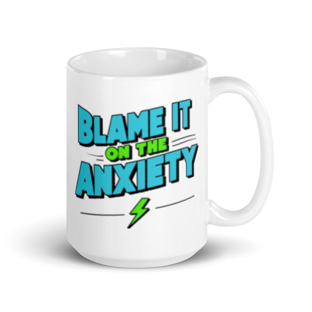 White ceramic mug with the phrase 'Blame is on the anxiety' printed on both sides of the mug. The graphics are bold and in aqua and lime green.