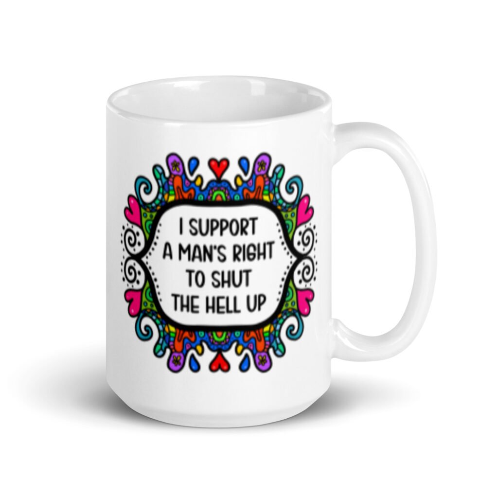 White ceramic mug with a colorful doodle graphic and the words 'I support a man's right to shut the hell up.' The design is printed on both sides of the mug.