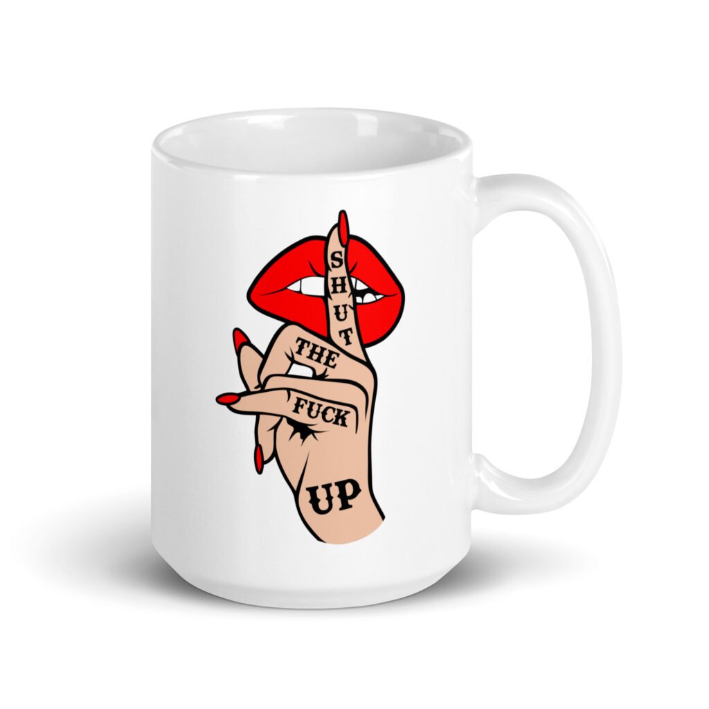 White ceramic mug with an image of a hand over lips making the shh gesture. The words 'Shut the fuck up' are printed on the hand. The graphics are printed on both sides of the mug.