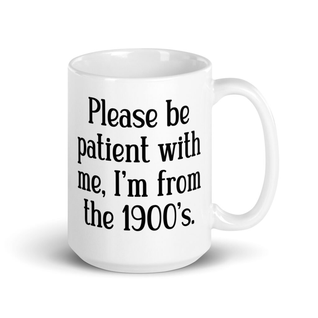 White ceramic mug with the text 'Please be patient with me, I'm from the 1900's' printed on both sides.