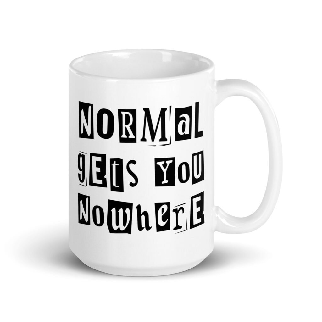 White ceramic coffee mug with the phrase 'Normal gets you nowhere' printed on both sides.
