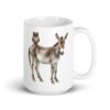 White ceramic coffee mug with an image of a donkey with wise owl sitting on it printed on both sides of the mug.