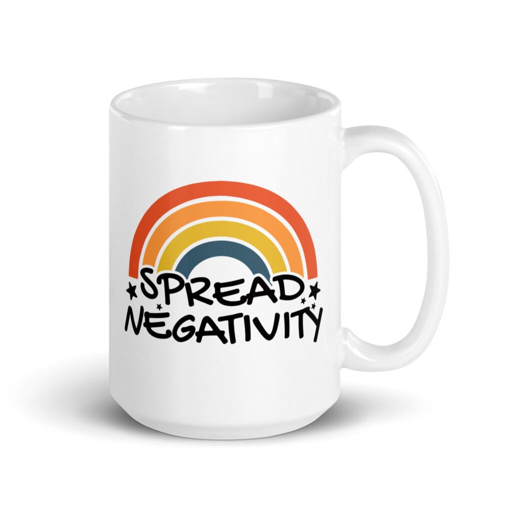 White ceramic coffee mug with a graphic of a rainbow and the words 'Spread negativity' printed on both sides.