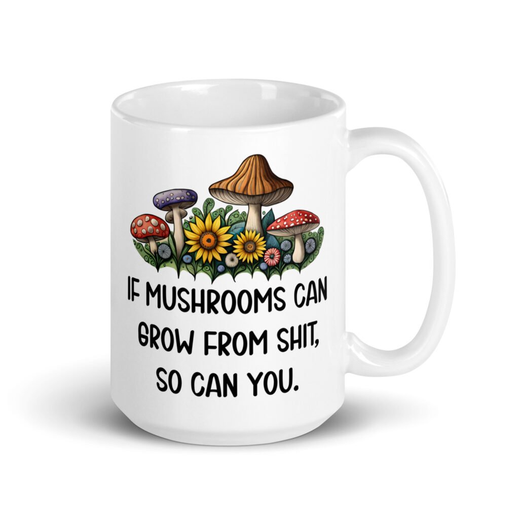 White ceramic coffee mug with images of mushrooms and the text 'If mushrooms can grow from shit so can you' printed on both sides.