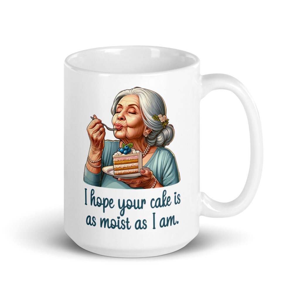 White ceramic coffee mug with an image of grey haired older woman enjoying a bite of a piece of cake with the words 'I hope your cake is as moist as I am' printed on both sides.