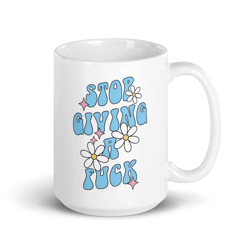 White ceramic coffee mug with a retro daisy and star design and the text 'Stop giving a fuck' printed on both sides.