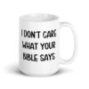 White ceramic coffee mug with the text 'I don't care what your bible says' printed on both sides.