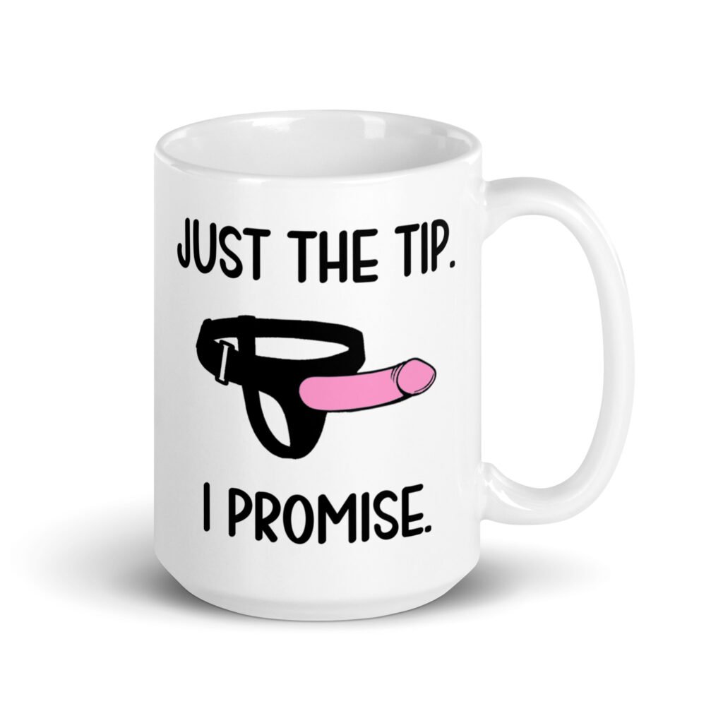 White ceramic coffee mug that has an image of a strap-on dildo and the words 'Just the tip. I promise.' printed on both sides.