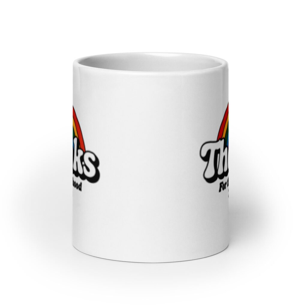 White ceramic mug with an image of a rainbow and the words 'Thanks for the childhood trauma' printed on both sides. The word Thanks is large and the rest of the words are smaller under.
