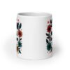 White ceramic mug with a multi color floral wreath design printed on both sides. The words 'One mental breakdown later...' are printed in the center of the wreath.
