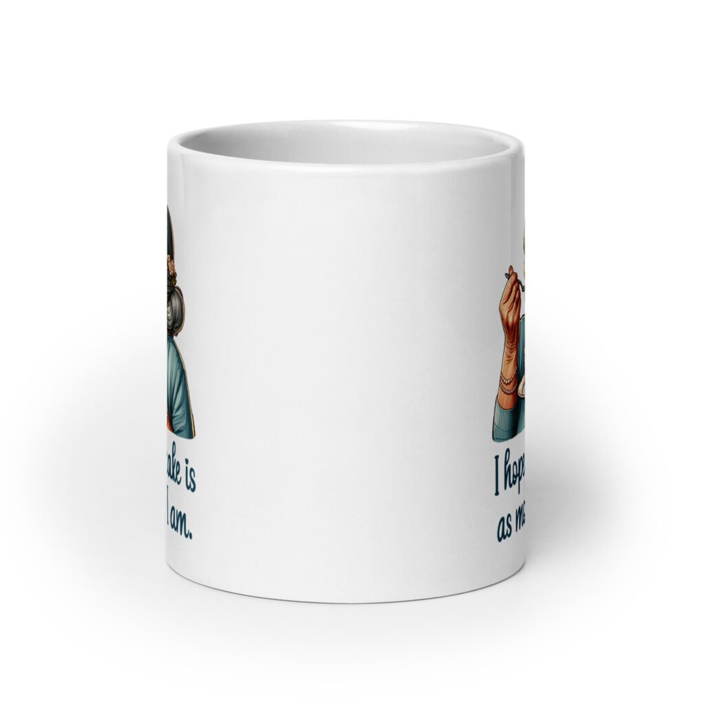 White ceramic coffee mug with an image of grey haired older woman enjoying a bite of a piece of cake with the words 'I hope your cake is as moist as I am' printed on both sides.